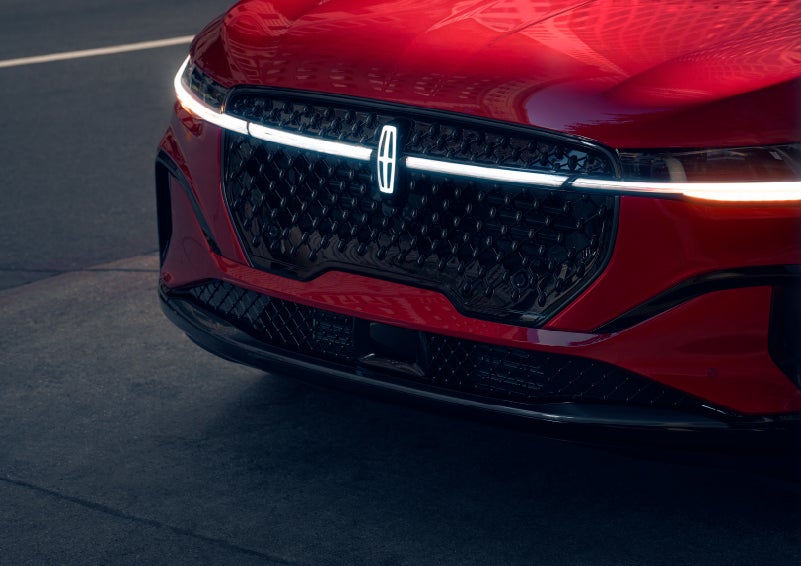 The available front LED light bar and center Lincoln Star logo glow at dusk. | Caruso Lincoln in Long Beach CA