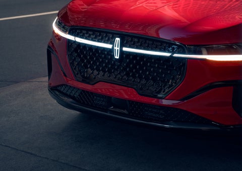 The available front LED light bar and center Lincoln Star logo glow at dusk. | Caruso Lincoln in Long Beach CA