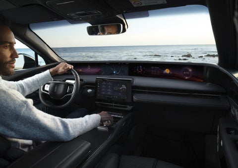 A driver of a parked 2026 Lincoln Nautilus® SUV takes a relaxing moment at a seaside overlook while inside his Nautilus. | Caruso Lincoln in Long Beach CA
