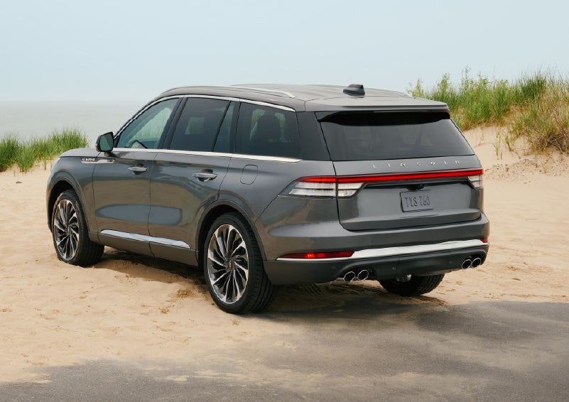 A 2027 Lincoln Aviator® SUV is parked next to sand dunes. | Caruso Lincoln in Long Beach CA