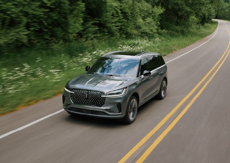A 2027 Lincoln Aviator® SUV is being driven down a road. | Caruso Lincoln in Long Beach CA
