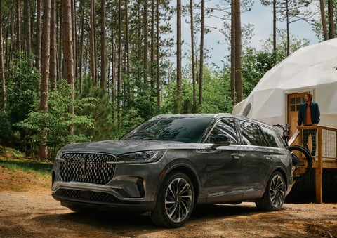 A 2027 Lincoln Aviator® is parked next to a high end glamping site. | Caruso Lincoln in Long Beach CA