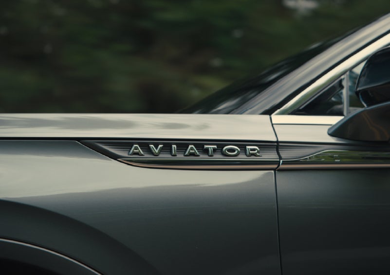 The driver’s side door and fender badging of a gray 2027 Lincoln Aviator® SUV are showcased. | Caruso Lincoln in Long Beach CA