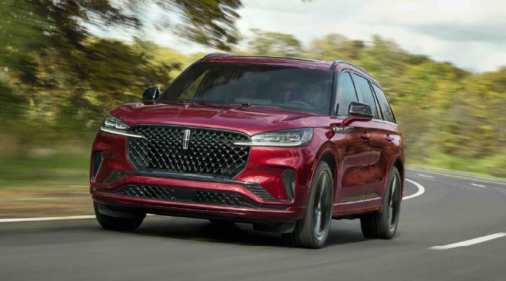 A 2027 Lincoln Aviator® SUV is being driven on a country road | Caruso Lincoln in Long Beach CA